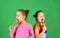 Children with busy faces pose with candies on green background