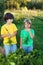 Children with a carrot in garden.