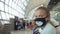 Children caucasian at airport with wearing protective medical mask on head against the background of plane. Coronavirus