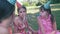 Children celebrate their birthday in the park while sitting on the grass.