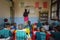 Children in classroom, teacher writes on whiteboard, Kathmandu, Nepal