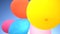 Children colored balloons seen from below against the sun, as a festive background