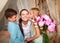 Children congratulate mother give her bouquet of flowers