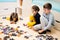 Children connecting jigsaw puzzle pieces in a kids room on floor at home. Fun family activity leisure