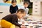 Children connecting jigsaw puzzle pieces in a kids room on floor at home. Fun family activity leisure