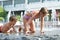 Children crawling in puddle on fountains of park