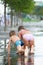 Children crawling in puddle on park