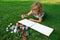 Children create artist paints creativity vacation. Kid draws in park laying in grass having fun on nature background.