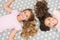Children curly hairstyle relaxing. Keep hair curly even next morning. Girls children with long hair lay on bed top view