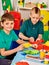 Children cutting paper in class. Development social lerning in school.