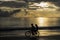 Children cycling on the beach on sunset, Thailand