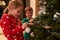 Children Decorating Christmas Tree At Home