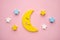 Children developmental toy for the development of motor skills, a crescent moon with stars balancer, on a pink background