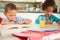 Children Doing Homework Together At Table