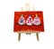 Children drawing representing three birds on red paper displayed on a wooden easel.