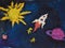 Children drawing rocket flying in space