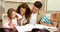 Children drawing at the table with their parents