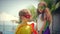 Children dressed in superhero costumes, cloaks and masks play heroes and have fun in the summer glade in the park