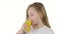 Children drinks orange juice, it is very tasty. White background. Slow motion