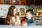 Children eat apples in the kitchen at the morning. The sister and brother hold the apple in their hands