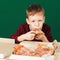 Children eat Italian pizza in the cafe. School boy eating pizza