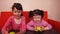 Children eating apples. Two sisters eating yellow apples while sitting on an orange couch.