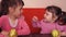 Children eating apples. Two sisters eating yellow apples while sitting on an orange couch.