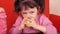 Children eating apples. Two sisters eating yellow apples while sitting on an orange couch.