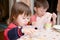 Children eating lunch at home, healthy food concept, kids enjoying bread and yogurt, sibling emotional faces, healthy breakfast