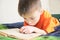 Children education, boy reading book lying on bed, child portrait with book, interesting storybook