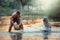 Children enjoying water splash on the creek with friends. Lifestyle of kids in rural of Thailand.