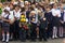 Children enrolled in the first class with bouquets of flowers and balloons in the hands, teachers and high school students on the