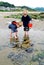 Children Explore Tide Pools with Red Bucket