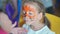 Children face painting. Artist painting with brash and special body paint tiger mask on face of little girl on carnival