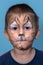 Children face painting. Boy painted as tiger or ferocious lion by make up artist. Preparing for theatrical performance. Boy actor
