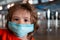 Children face in a protective mask. Frightened scared boy kid. Beautiful childrens eyes. Children and coronavirus