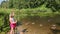 Children feed ducks that swim in the river.