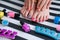 Children is feet with bright pedicure and manicure of different colors and bottles of bright nail polish. Little girl does a