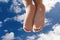 Children feet under a cloudy blue sky