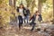 Children in a forest running to camera, father looking on