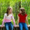 Children friend girls talking on the jungle park forest