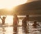 Children With Friends Enjoying Evening Swim In Countryside Lake