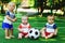 Children friendship: three little kids at sports ground with soccer ball. Tiny football team learning to play and to walk