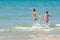 Children fun and funny run swimming in the sea, left empty place for insertion