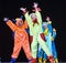 Children in funny colored overalls aliens dancing on stage