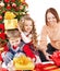 Children with gift box near Christmas tree.