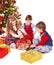Children with gift box near Christmas tree.
