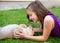 Children girl playing with chihuahua dog lying on lawn