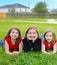 Children girls group lying on lawn grass smiling happy