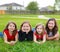 Children girls group lying on lawn grass smiling happy
